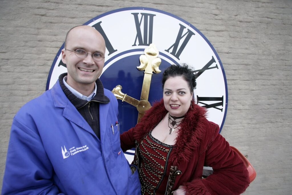Arbeitsbühnenmontage der rückwärtslaufenden Turmuhr am Münchner Isartor, Foto mit Sören Draack und Münchner Künstlerin Petra Perle